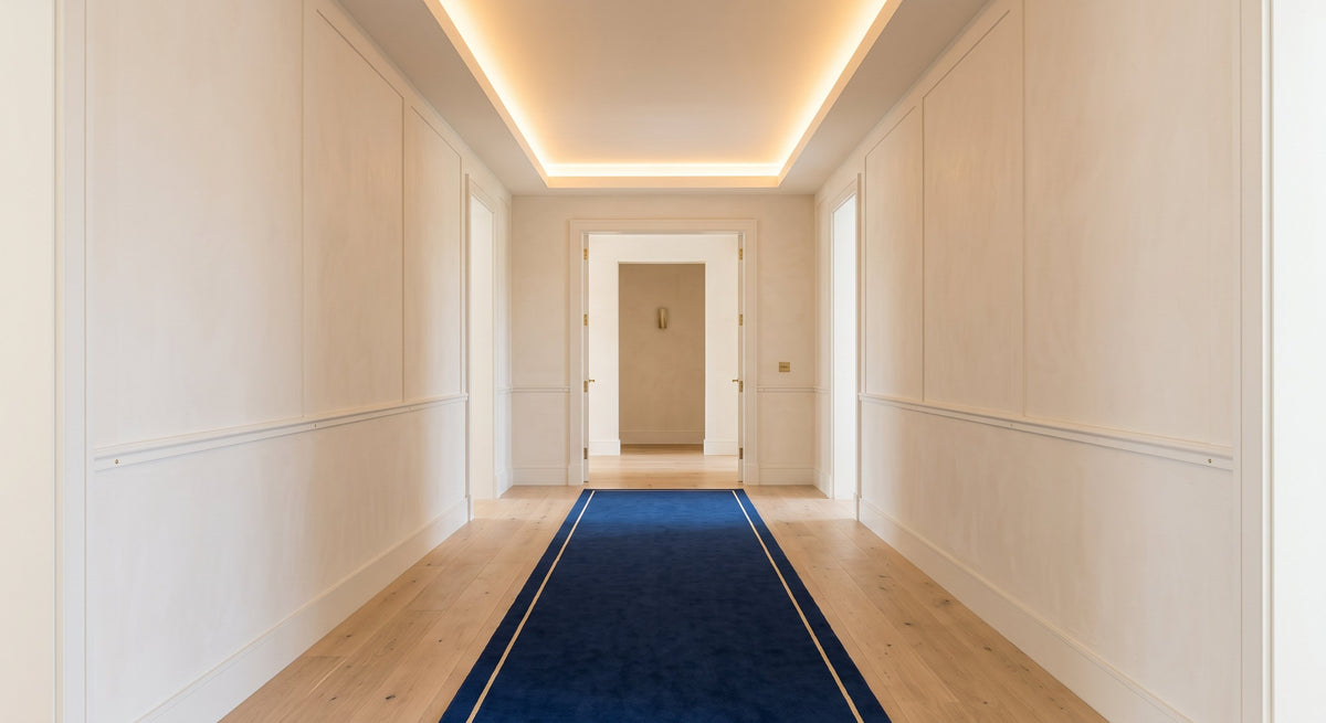 Long bright hallway with a navy runner